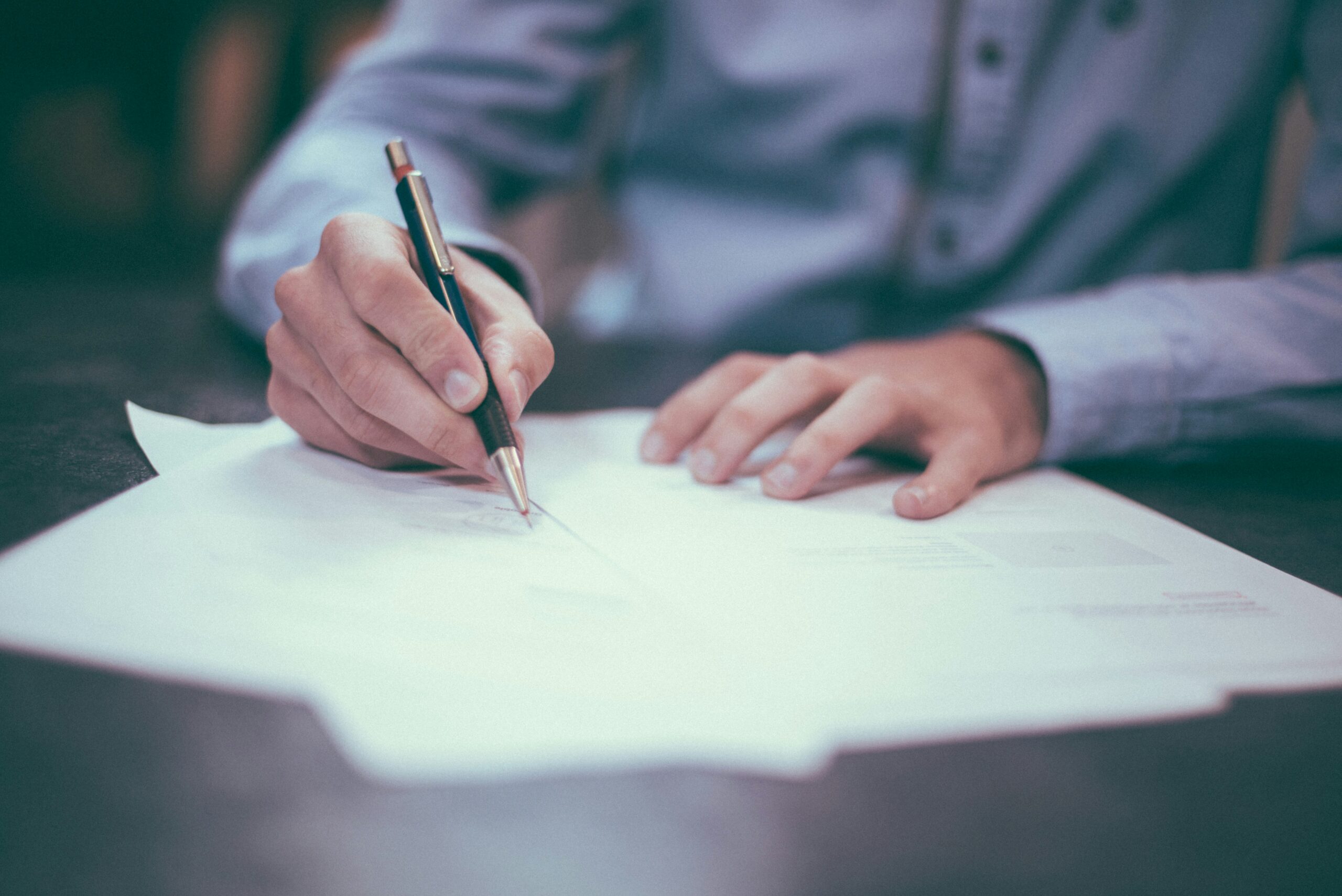 closeup of someone signing papers
